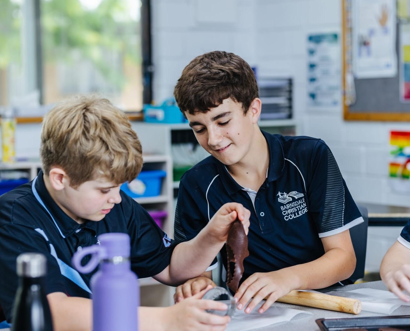 Two primary boys working together on a classroom activity, modelling teamwork, kindness, and Christ-like character at a Bairnsdale Christian school.
