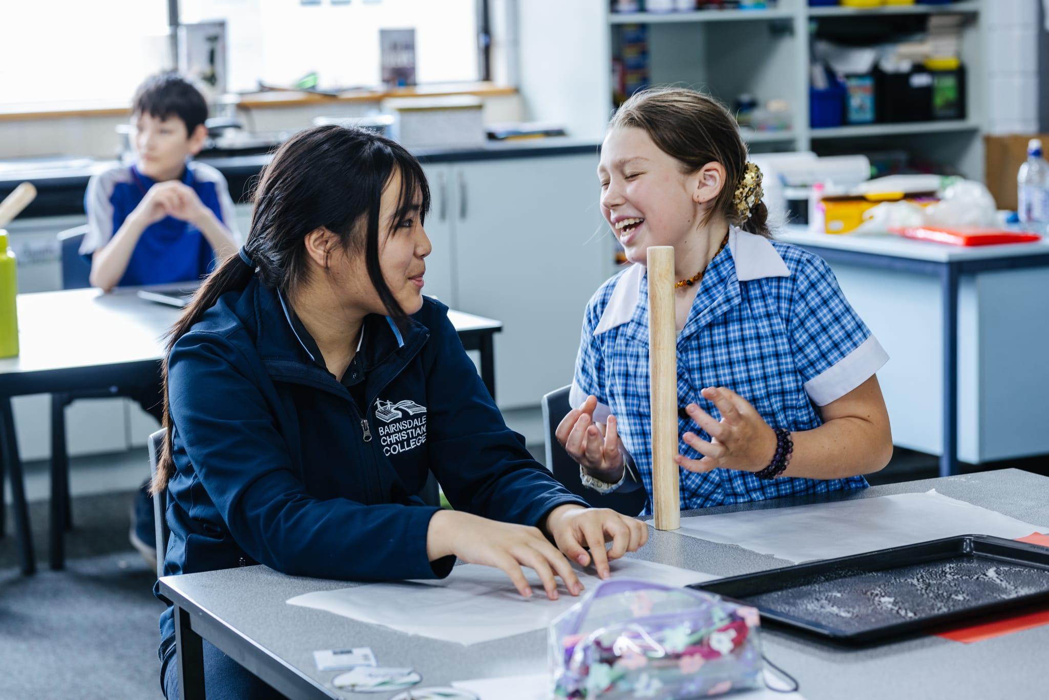 Two students enjoying a hands-on learning activity together in a classroom at Bairnsdale Christian College.