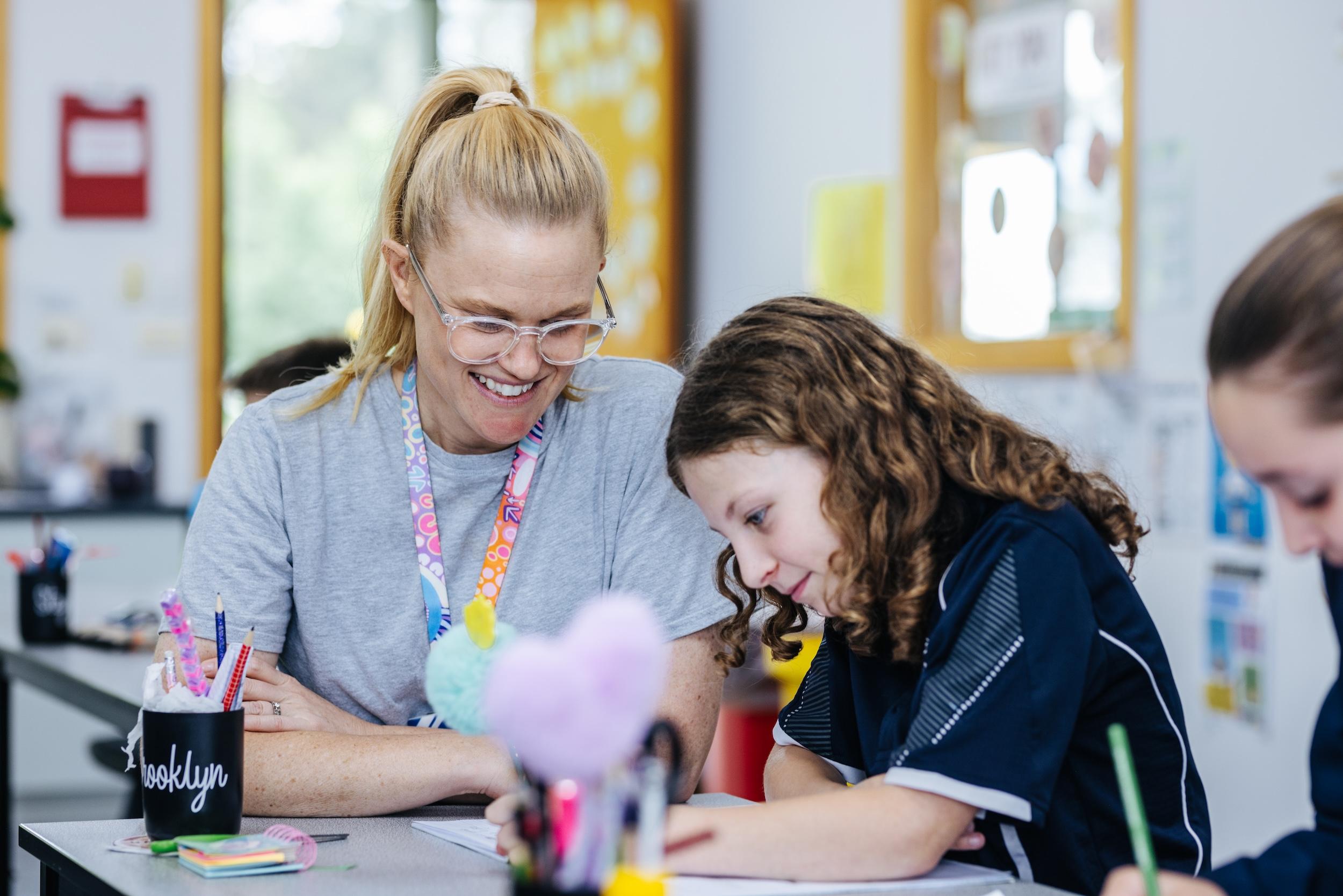Christian school teacher mentoring a primary student in a supportive classroom at Bairnsdale Christian College, reflecting the joy and purpose of gospel-centred teaching.