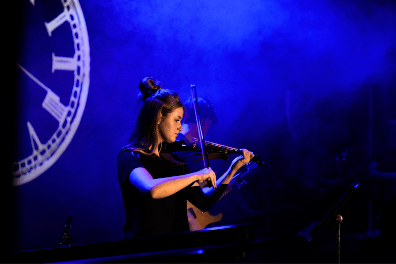 Female student performing violin for musical