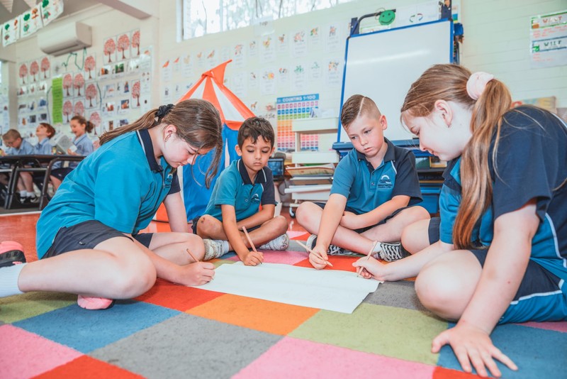 Students sitting on floor of Lake Macquarie classroom drawing together
