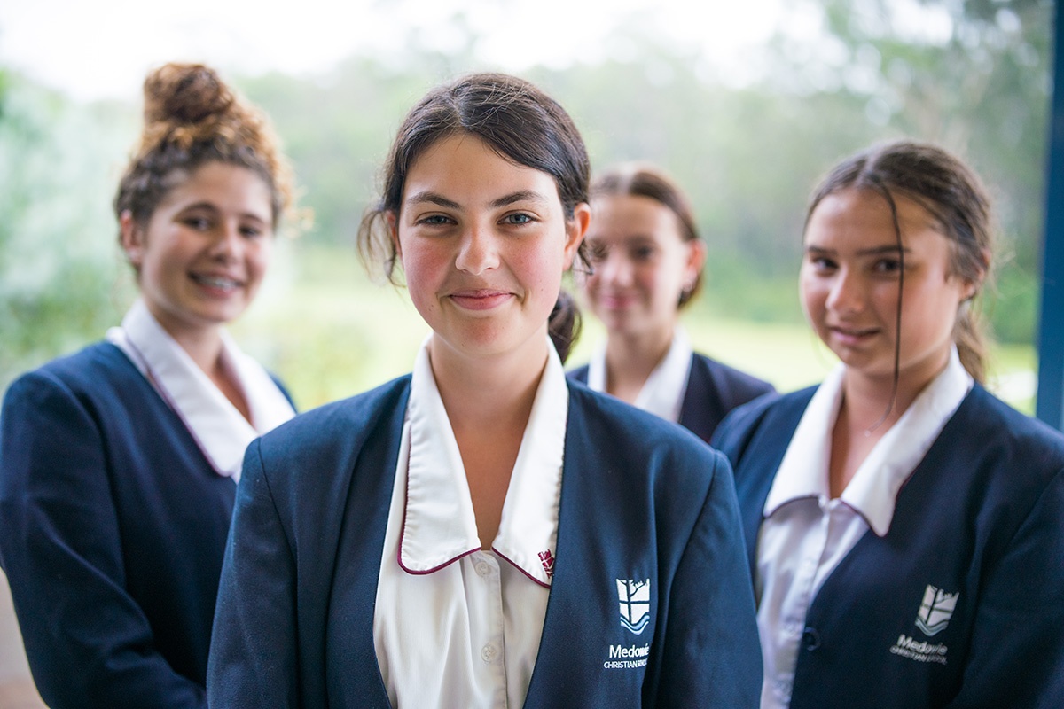 group of smiling high school girls in formal uniform