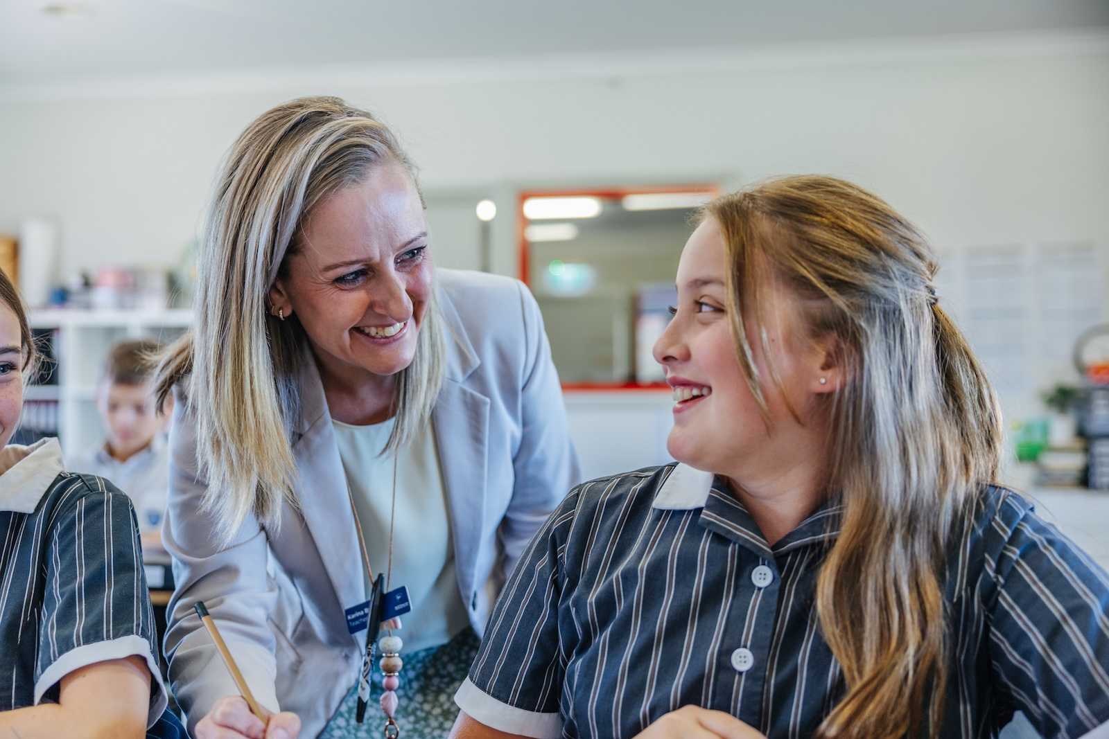 young female teacher giving piggyback to young aboriginal students on outback mission trip